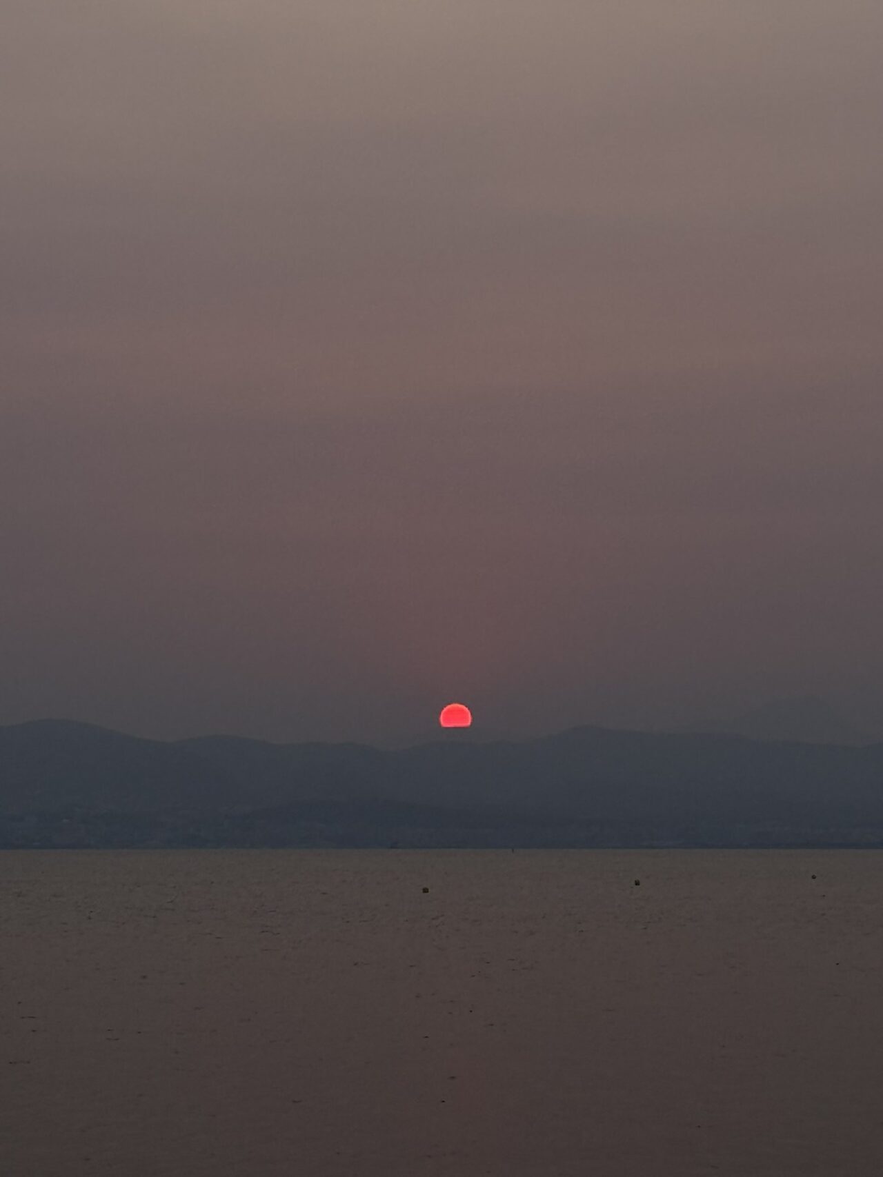 Sol rojo sobre el horizonte al atardecer.