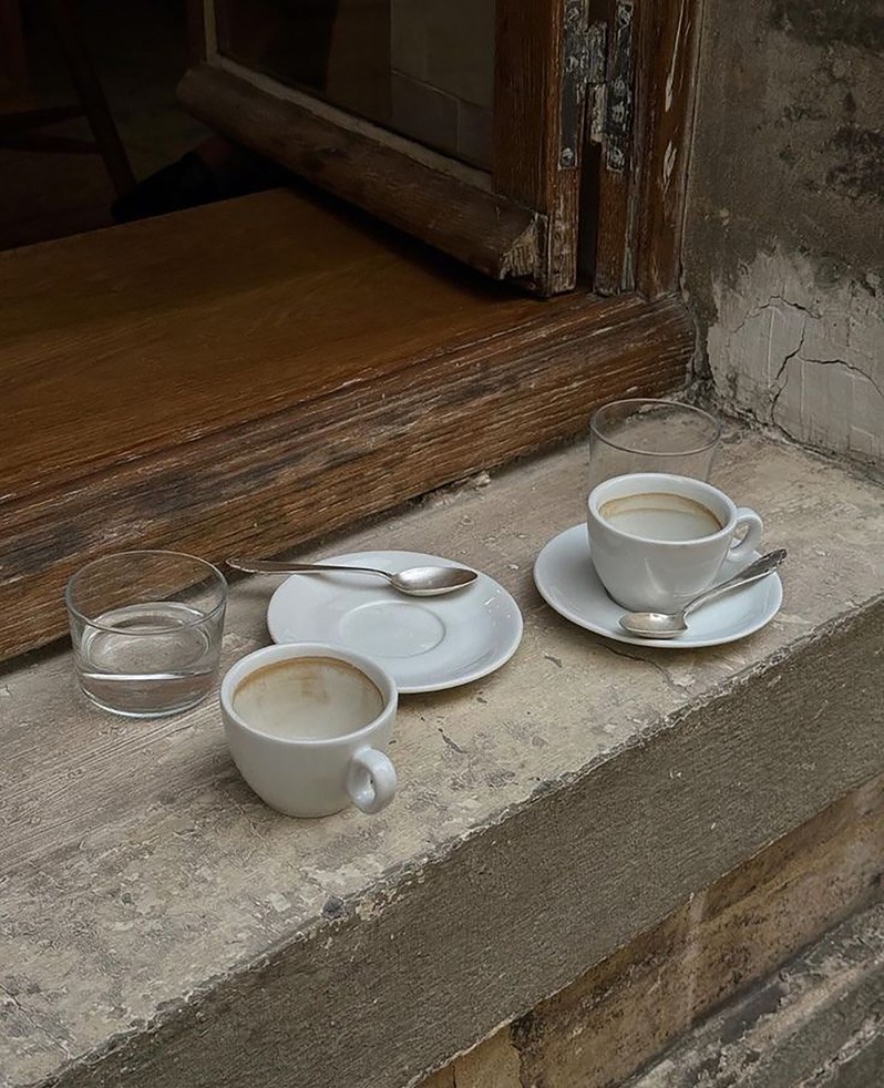 Tazas de café sobre un alféizar de piedra.