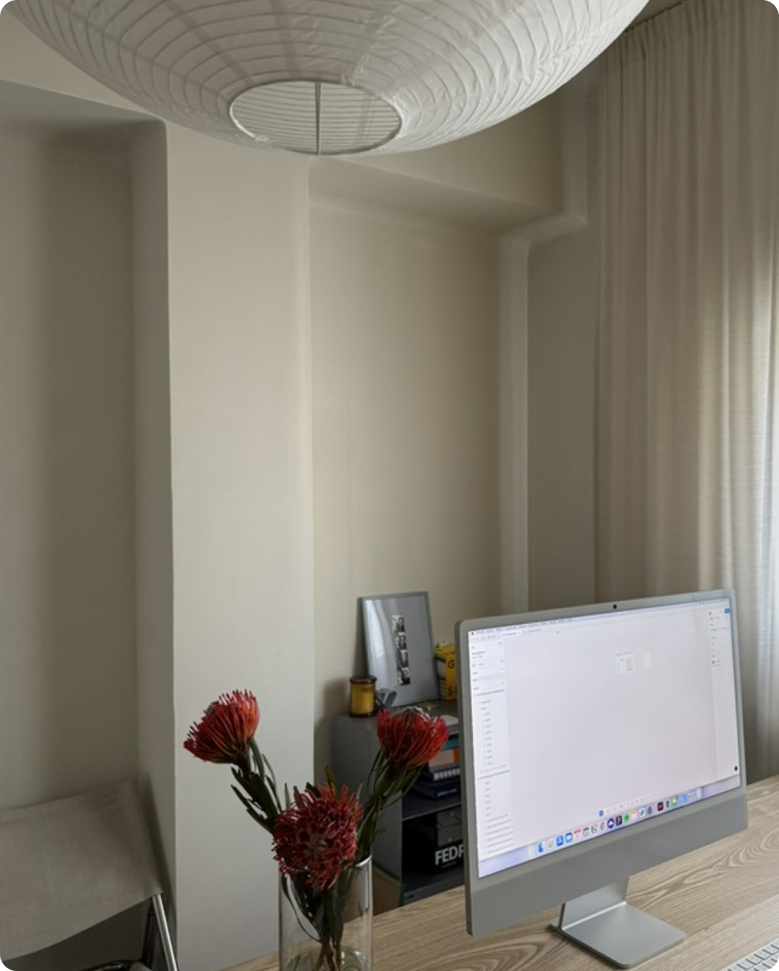 Ordenador y flores sobre una mesa de madera en el estudio.