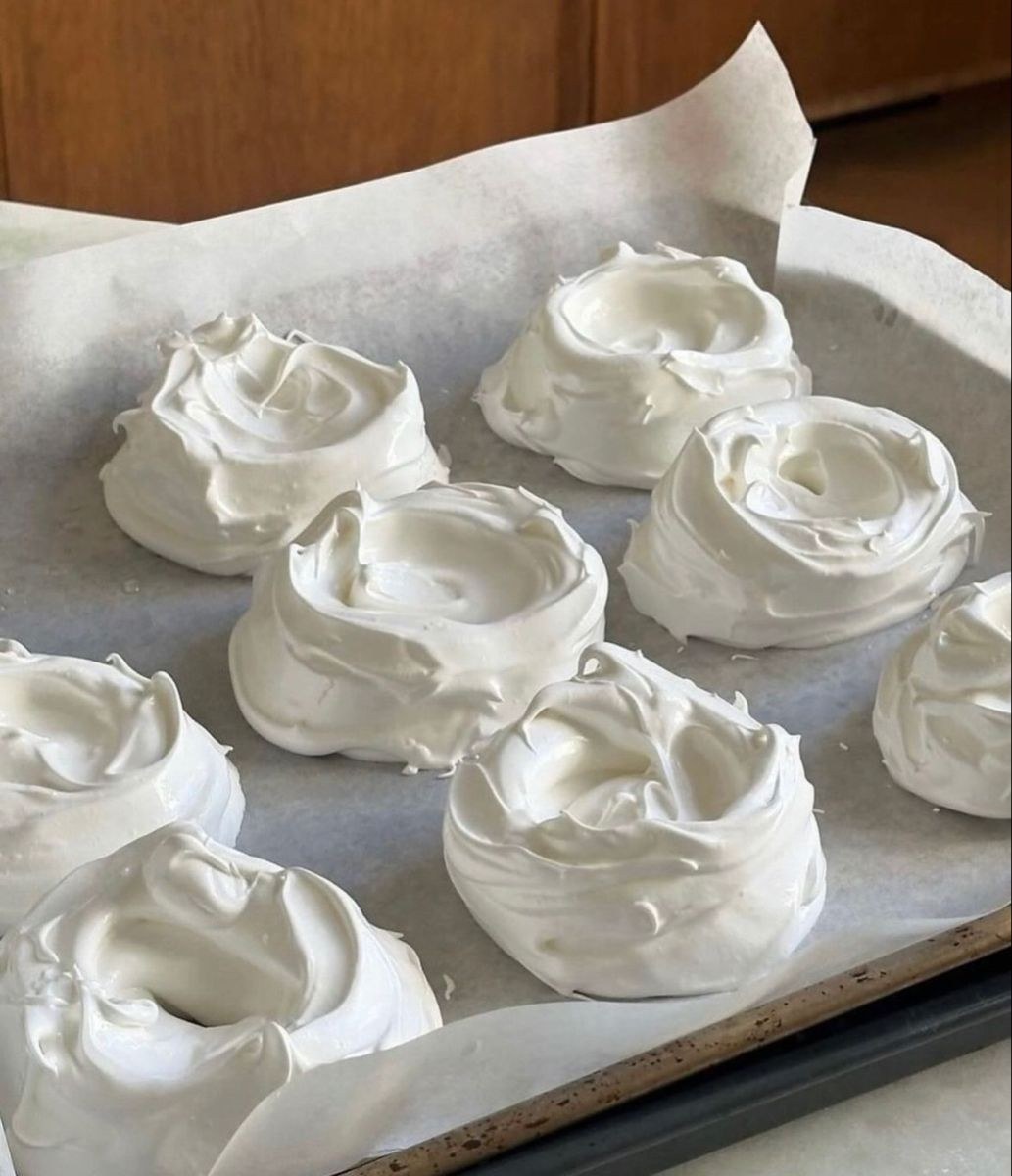 Piezas con formas circulares blancas sobre papel de horno.