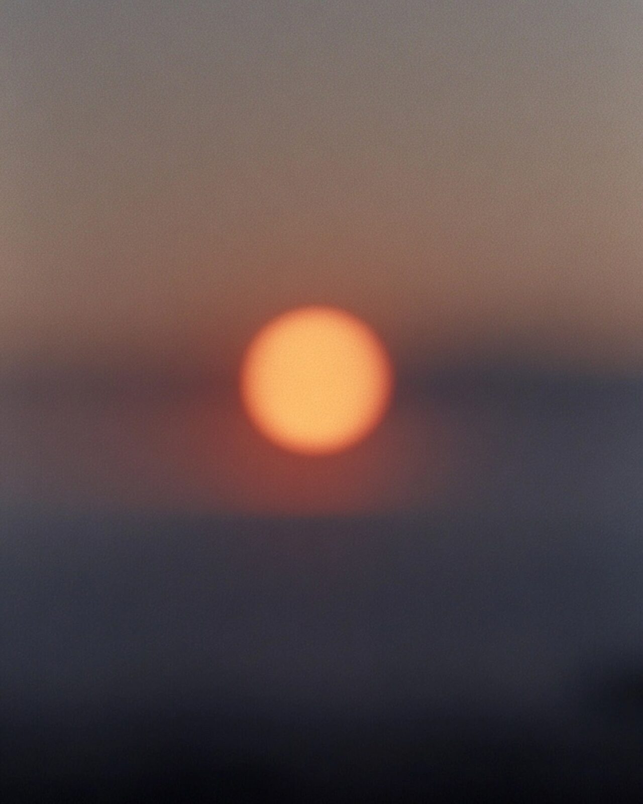 Disco solar desenfocado sobre un horizonte oscuro.