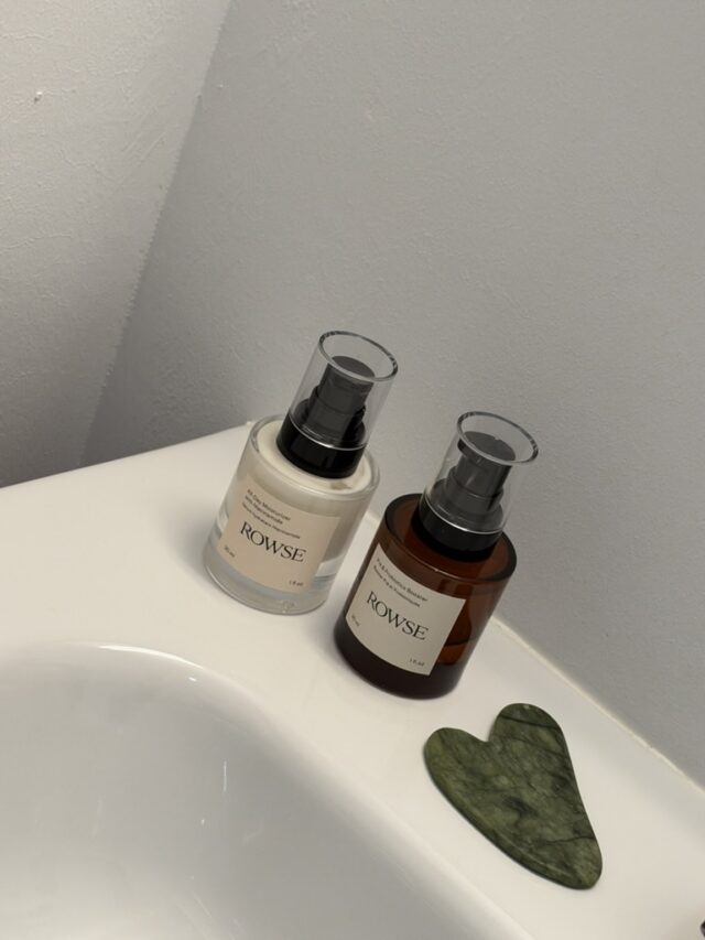 Dos productos de cuidado facial y una piedra gua sha junto al lavabo.