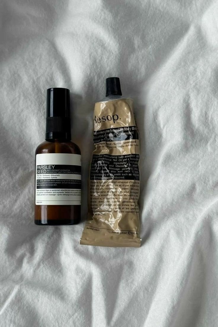 Un frasco y un tubo de Aesop sobre una tela blanca.