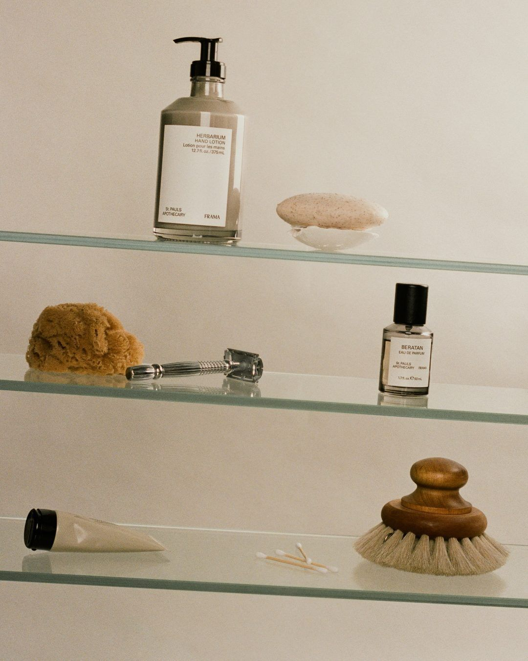 Estanterías de cristal con productos y accesorios de baño.