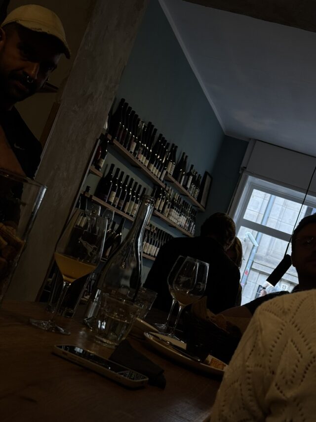 Interior de un bar con barra y estantes de botellas.