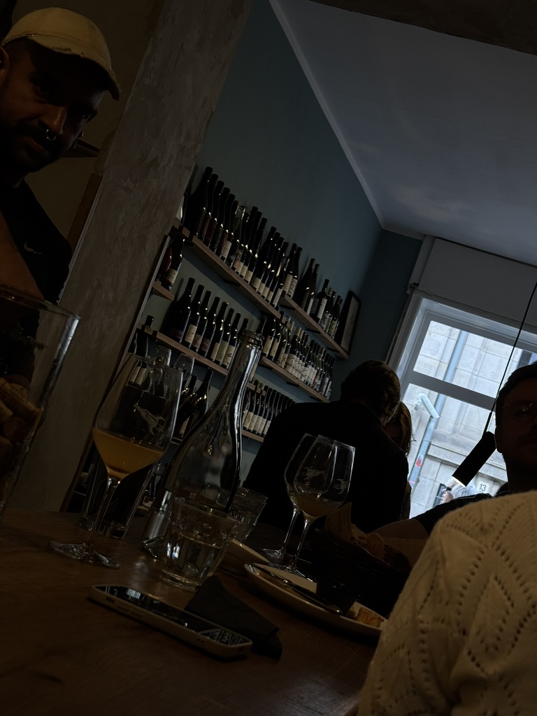 Interior de un bar con barra y estantes de botellas.