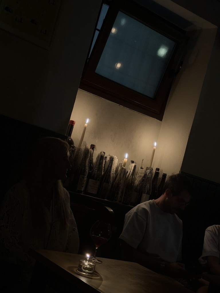 Una mesa con una vela encendida en un interior de luz tenue.