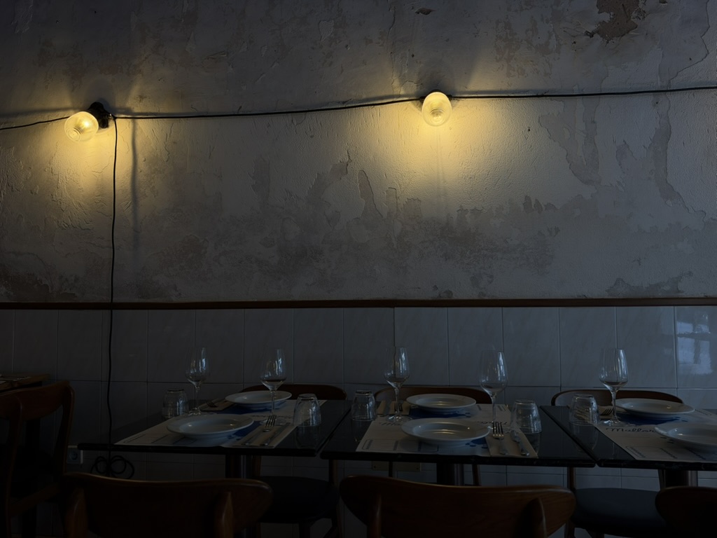 Mesas preparadas y dos lámparas de pared en Bar Reisancho.