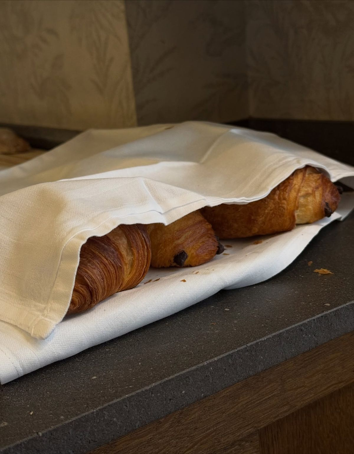 Croissants sobre una bandeja parcialmente cubierta con papel.
